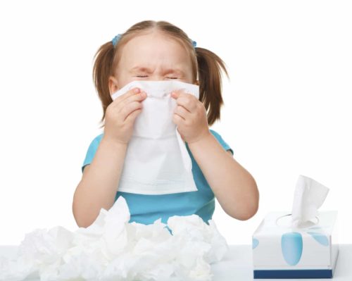 little girl blowing her nose into a tissue