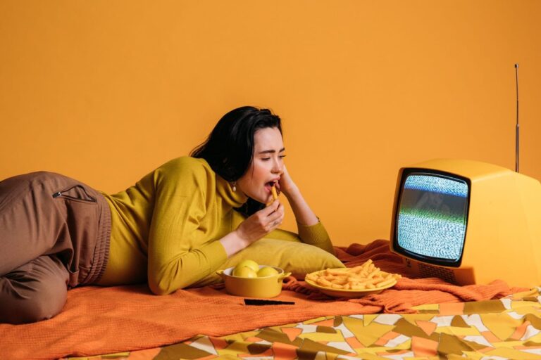 woman snacking while watching on a vintage TV